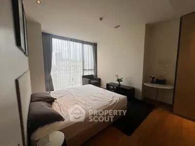 Modern bedroom with large window and city view, featuring elegant decor and cozy ambiance.