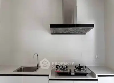 Modern kitchen with sleek gas stove and stainless steel sink, perfect for culinary enthusiasts.