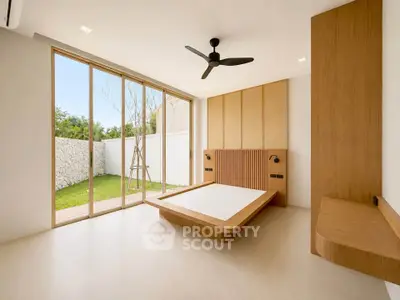 Modern minimalist bedroom with large windows and garden view