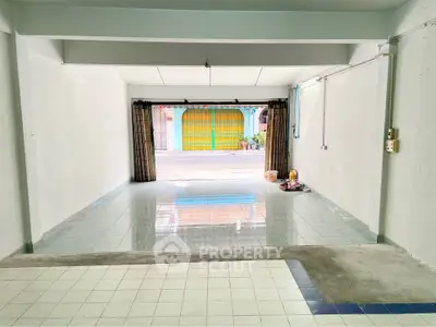 Spacious garage with tiled flooring and street view, ideal for parking or storage.