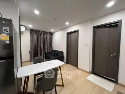 Modern apartment interior with sleek dining area and cozy living space, featuring contemporary furniture and lighting.