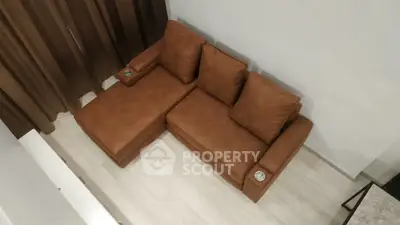 Stylish brown sectional sofa in modern living room with light wood flooring and elegant curtains.