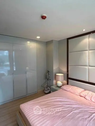 Modern bedroom with sleek design, featuring a cozy bed, stylish wardrobe, and elegant lighting.