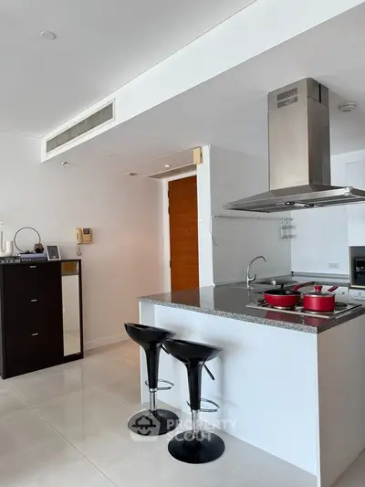Modern kitchen with sleek island and bar stools in stylish apartment