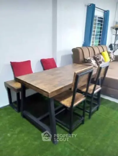 Cozy dining area with wooden table and chairs on green carpet, perfect for modern interiors.