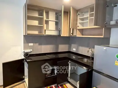 Modern kitchen with sleek black countertops and ample cabinet space in a contemporary apartment.