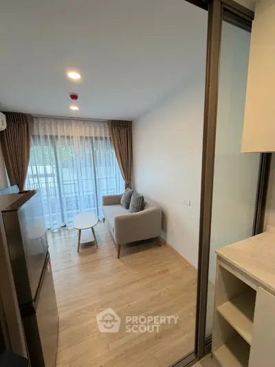 Modern living room with cozy sofa and natural light, featuring wooden flooring and stylish decor.