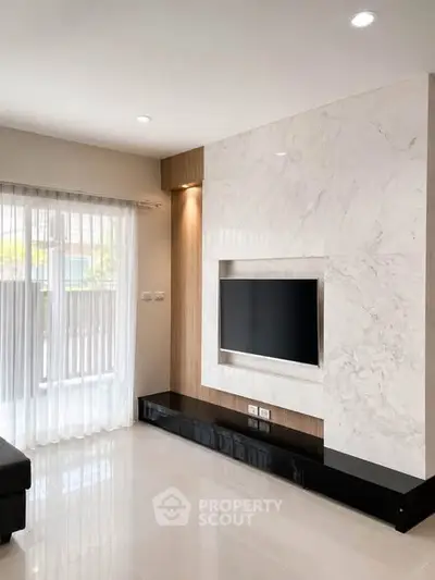 Modern living room with marble TV wall and large window for natural light.