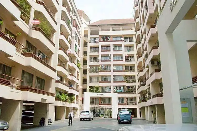Spacious apartment complex with modern design and ample parking space.