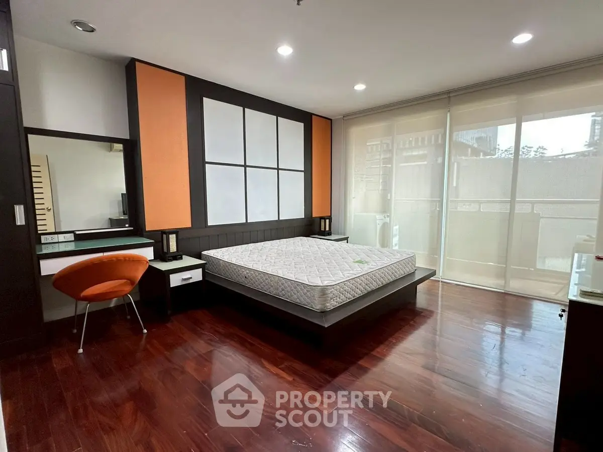 Spacious modern bedroom with hardwood floors and stylish decor