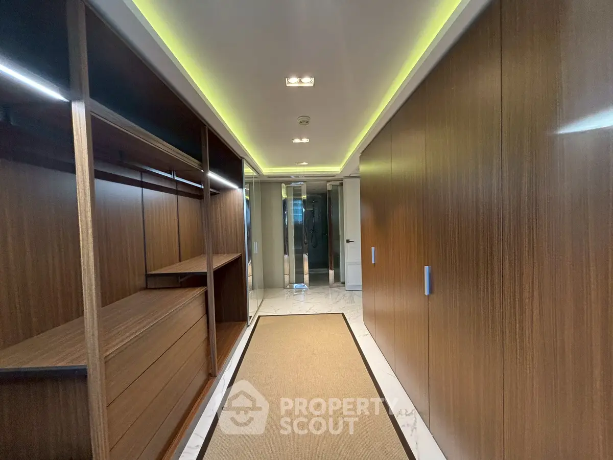 Luxurious walk-in closet with wooden finishes and modern lighting