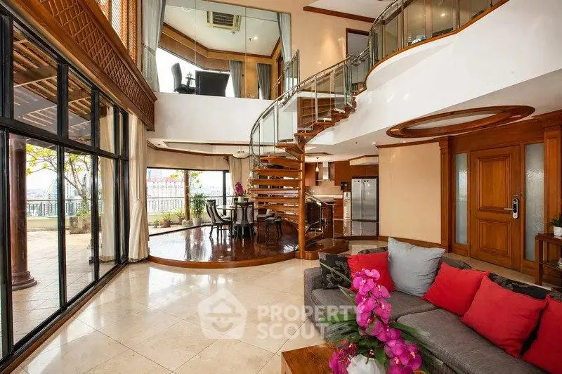 Luxurious open-plan living room with spiral staircase and large windows offering stunning views.