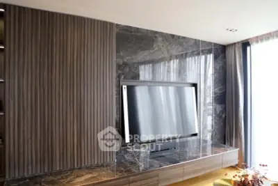 Luxurious modern living room with sleek TV setup and elegant marble accents.