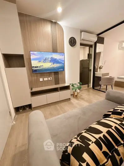 Modern living room with stylish decor and wall-mounted TV in a cozy apartment.
