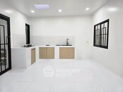 Modern minimalist kitchen with sleek white tiles and open layout