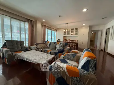 Spacious living room with modern furniture and large windows in a stylish apartment.