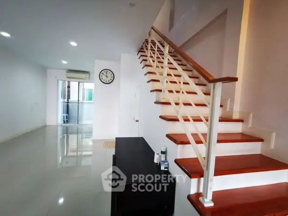 Spacious modern living room with sleek staircase and minimalist design