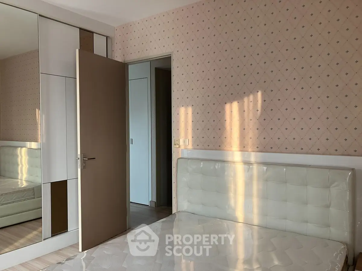 Spacious bedroom with modern wardrobe and elegant headboard, perfect for comfort and style.