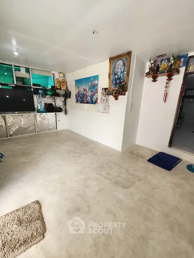 Spacious living room with minimalist decor and wall art, ideal for cozy gatherings.