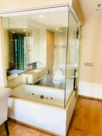 Luxurious modern bathroom with glass-enclosed bathtub and sleek fixtures