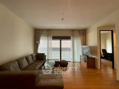 Spacious living room with modern furniture and large window for natural light.