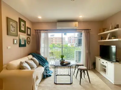 Cozy living room with balcony view, stylish decor, and natural light