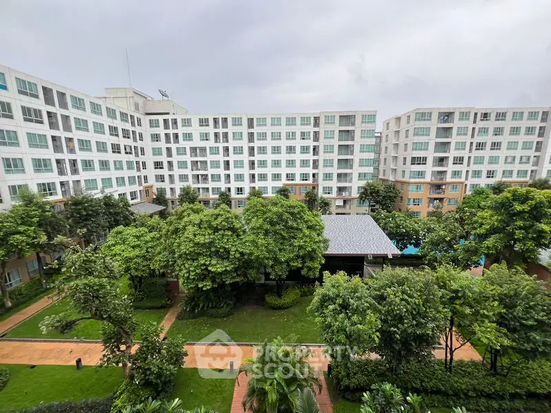 Modern apartment complex with lush green gardens and spacious outdoor area.