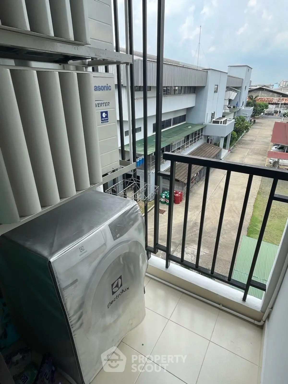 Compact balcony with washing machine and city view