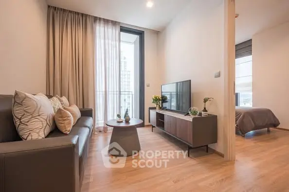 Modern living room with sleek furniture and natural light, adjacent to a cozy bedroom.