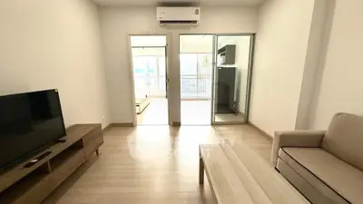 Spacious living room with modern furniture and balcony access in a stylish apartment.