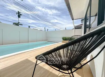 Stunning poolside view with modern patio seating and clear blue skies.