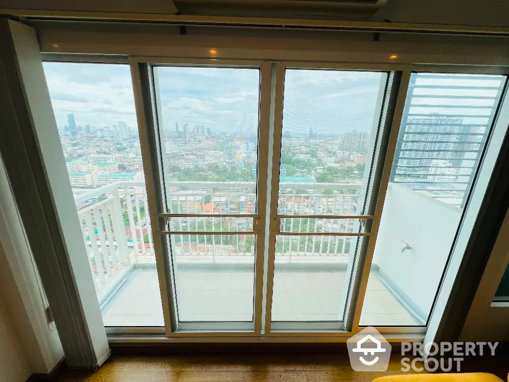 Stunning cityscape view from high-rise balcony with sliding glass doors