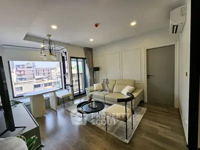 Modern living room with stylish decor and large windows offering city views.