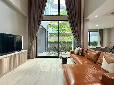 Spacious modern living room with large windows and stylish leather sofa