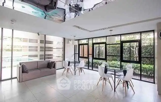 Spacious modern living room with large windows and garden view, featuring sleek furniture and elegant design.