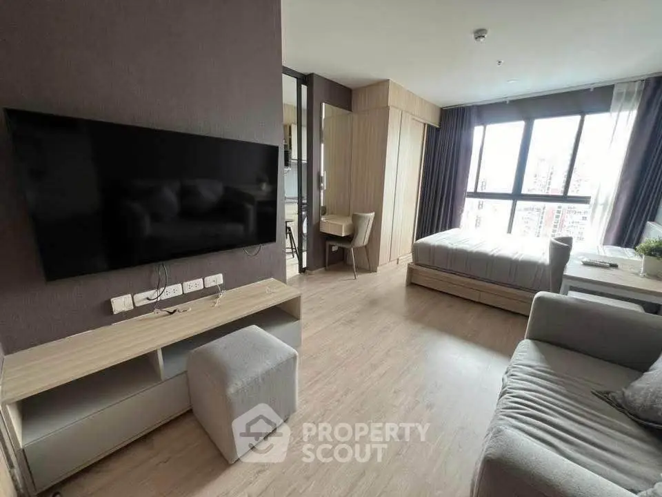 Modern studio apartment with sleek design and large windows offering city views.