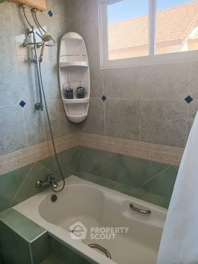 Charming bathroom with bathtub and shower, featuring elegant tile design and natural light.