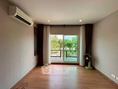 Spacious living room with balcony view and air conditioning in modern apartment.