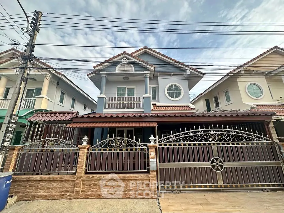 Charming two-story house with gated entrance and unique architectural design.