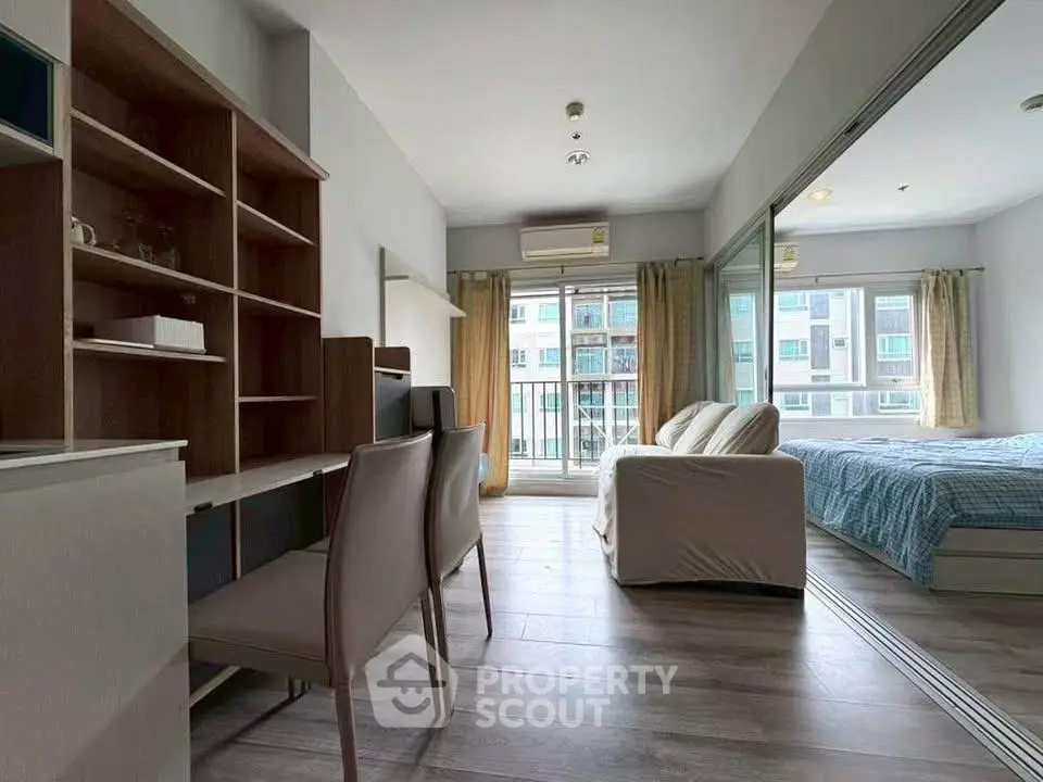 Modern studio apartment with open layout, featuring a cozy living area, study desk, and large windows for natural light.