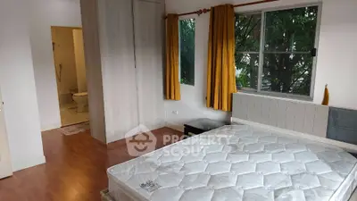 Spacious bedroom with large window and ensuite bathroom in modern apartment