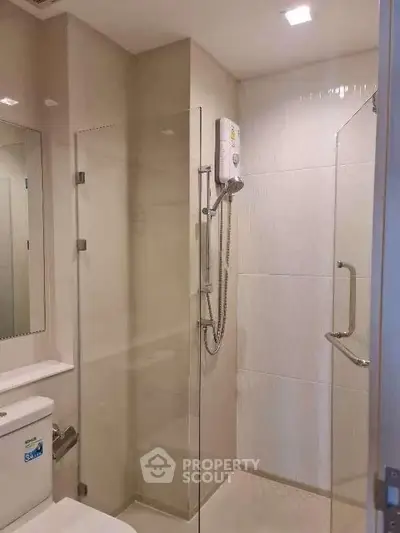 Modern bathroom with glass shower enclosure and sleek fixtures