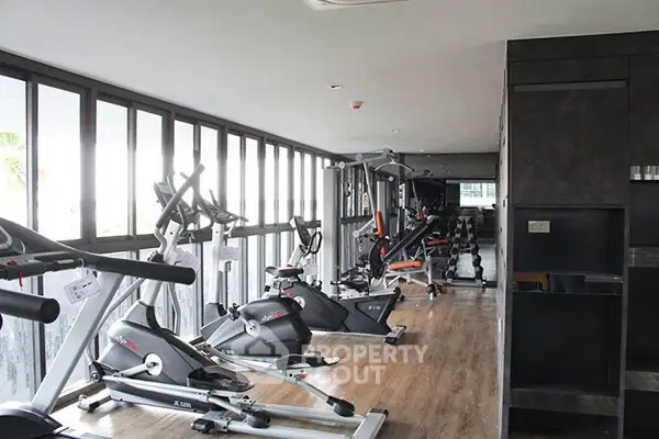 Modern gym with state-of-the-art equipment and large windows for natural light.