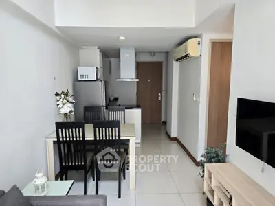 Modern open-layout living room with dining area and kitchen in a compact apartment.