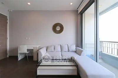 Modern living room with large windows and balcony access, featuring a stylish sofa and sleek decor.