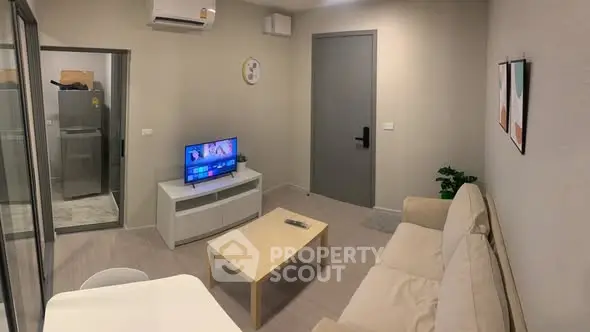 Modern living room with cozy sofa and flat-screen TV in a stylish apartment.