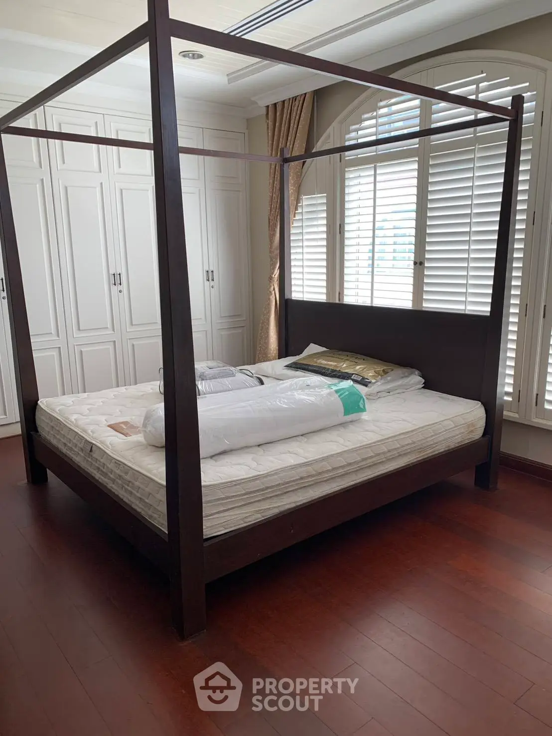 Spacious bedroom with elegant four-poster bed and ample natural light.