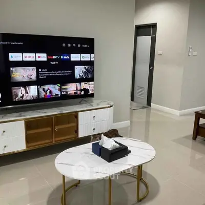 Modern living room with sleek TV setup and stylish marble coffee table.