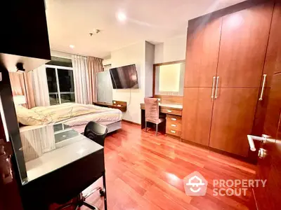 Spacious bedroom with modern furnishings and hardwood floors in a luxury apartment.