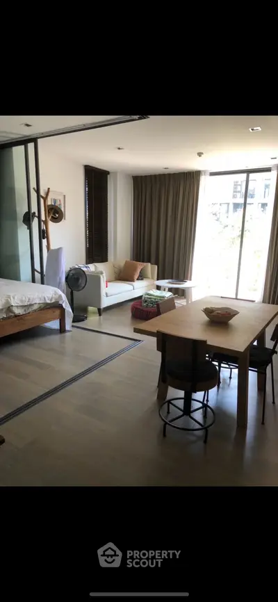 Spacious open-plan living room with dining area and large windows